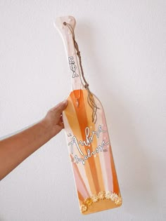 a person holding an orange and white bag with the word aloha on it