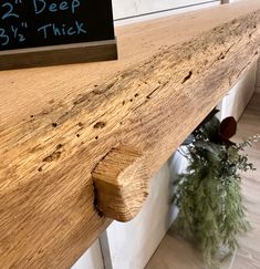 a close up of a wooden shelf with a sign on it that says deep by thick