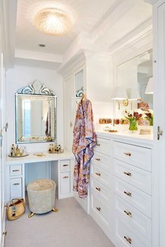 a bathroom with white cabinets and drawers