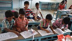 there are many children sitting at desks with books