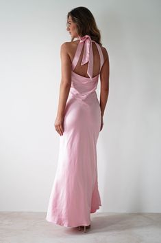 a woman wearing a pink dress with a bow back