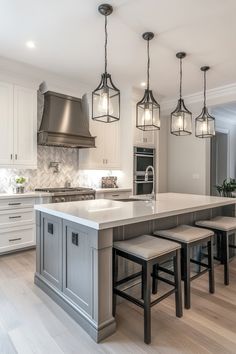 Modern kitchen with a large island, pendant lights, and stainless steel appliances. White Gray Home Decor, Grey Aesthetic Kitchen, White Countertops Gray Cabinets, Grey And Cream Kitchen Ideas, Home Decor Ideas White And Grey, Gray White And Wood Kitchen, White Cabinets With Gray Island, Modern Gray Kitchen Design, Kitchen Ideas With White Countertops