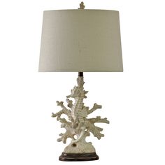 a table lamp with a white coral on it and a beige shade over the base