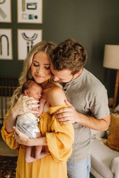 a man and woman holding a baby in their arms