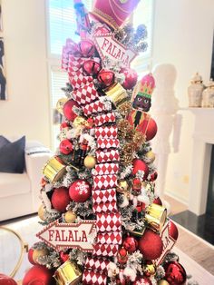 a christmas tree decorated with red and gold ornaments in a living room, featuring the name faliaa