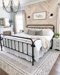 a bedroom with a bed, dressers and a chandelier hanging from the ceiling