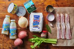 the ingredients to make this dish are laid out on a wooden table, including onions, celery, bacon, and eggs