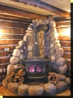 a wood burning stove in a log cabin with logs stacked on the floor around it