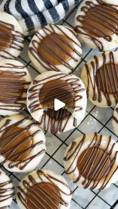 cookies with chocolate drizzled on them sitting on a cooling rack