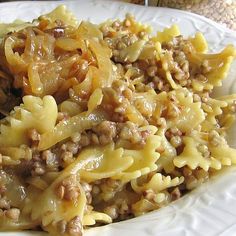 a white plate topped with pasta and meat