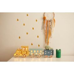 a toy train is sitting on a shelf next to a wall hanging with raindrops