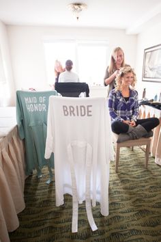 two women sitting on chairs in front of a t - shirt with the word bride written on it