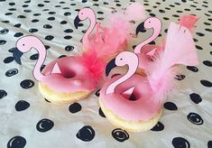 two donuts with pink frosting and pink flamingos on them sitting on a polka dot tablecloth