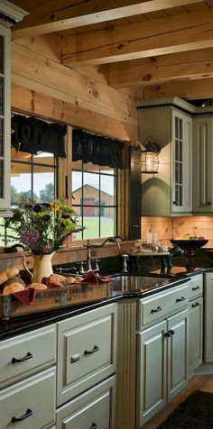 a kitchen with white cabinets and black counter tops