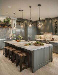 a kitchen island with stools in front of it and lights hanging above the island