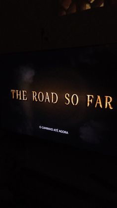 the road so far sign lit up at night