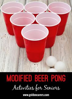 red cups filled with beer sitting on top of a wooden table next to white balls