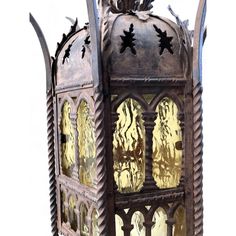 an old metal lantern with ornate carvings on the front and sides, set against a white background