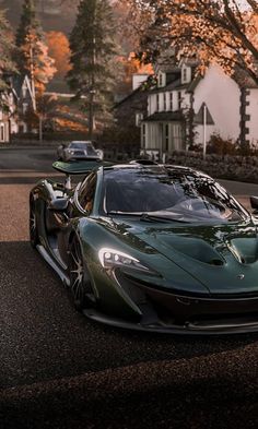 the green sports car is parked on the side of the road in front of some houses