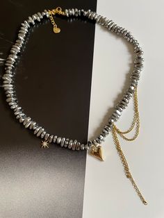 Indulge in pure luxury with our dark gray stoned necklace adorned with gold embellishments. The perfect combination of sophisticated and exclusive, this necklace is a must-have for any fashion-forward individual. Elevate any outfit and make a statement with this elegant piece of jewelry. Elegant Silver Choker With Gold Chain, Gold Metal Collar Beaded Necklaces, Gold Metal Beaded Necklace With Clavicle Chain, Gold Beaded Clavicle Chain Necklace, Elegant Silver Beaded Necklaces With Gold Beads, Chic Gold Jewelry With Gold Beads, Gold Metal Crystal Choker Necklace, Silver Gold-plated Chain Necklace For Party, Silver Gold-plated Necklace For Party