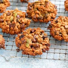 cookies cooling on a wire rack with nuts and chocolate chips in the top one is oatmeal