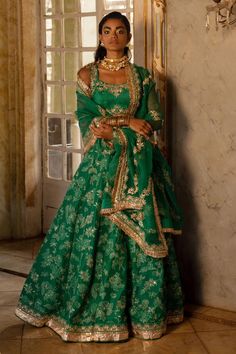 Emerald green self woven Russian jacquard lehenga with floral and animal motifs highlighted with embroidery. Comes with embroidered, padded blouse and tissue base dupatta with antique gold resham and embellished hand work. 
Components: 3
Pattern: Woven, Embroidered
Type Of Work: Floral and Animal Patterns, Resham Work
Neckline: Scoop
Sleeve Type: Sleeveless
Fabric: Lehenga and blouse : Russian Jacquard, Dupatta : Tissue
Color: Emerald Green
Other Details: 
Lehenga:
Attached lining
Embroidered hi Seasonal Weddings, Jacquard Lehenga, Paulmi And Harsh, Intricate Mirror, Green Sari, Mehndi Dress, 1950’s Fashion, Lime Yellow, Green Lehenga