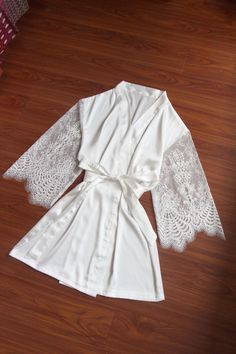 This robe is very special and beautiful, with sheer lace sleeves Free size for US2-12 Length: above knee length, about 33-34 inches length fabric: satin cream white color Sleeves: Sheer lace sleeve, long Sleeve Please know the robe is a bit see through for white fabrics, and sleeves part is sheer lace fabric, avoid dark color underwear, and please wear a slip dress underneath if needed Thank you so much Fitted Robe With Lace Sleeves For Wedding Night, Fitted Wedding Night Robe With Lace Sleeves, Elegant Wedding Robe With Lace Cuffs, Wedding Night Satin Robe With Lace Sleeves, Elegant Lace Robe With Lace Cuffs, Elegant Robe With Lace Sleeves For Wedding Night, Fitted Wedding Robe With Lace Sleeves, Fitted Lace Sleeves Wedding Robe, Fitted Cream Robe For Wedding