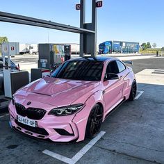 a pink car parked at a gas station