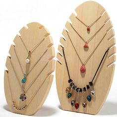 two wooden display boards with necklaces and earring holders on top of each other