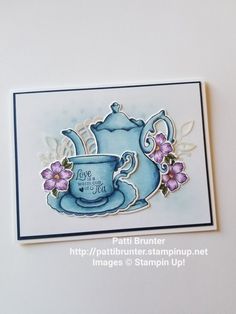 a handmade card with a teapot and flowers on the front, in blue