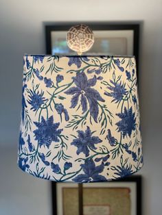 a blue and white lamp sitting on top of a table next to a framed photo