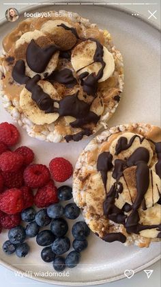 two desserts on a plate with raspberries and blueberries