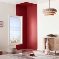 a living room with red walls and white carpeted flooring next to an open window