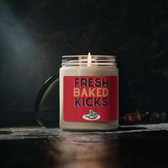 a candle that is sitting on top of a table with the words fresh baked kicks printed on it