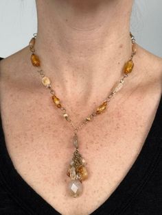 Handmade natural gemstone beaded necklace for person with a petite neck. This is an antiqued gold-tone single chain necklace comprised of polished citrine beads, golden glass beads, multicolored Japanese glass seed beads. This beaded necklace has a pendant of a cluster of citrine beads, multicolored Japanese glass seed beads and rutilated quartz and is closed with a antiqued gold-tone toggle-clasp. This is a golden, light yellow and amber colored handmade chunky necklace with beads and gemstones. Characterized by a free-spirited and unconventional look featuring natural materials, asymmetrical design, and a mix of colors and textures, this small bohemian chic necklace can be worn whenever someone wants to add a touch of boho flair to their outfit, whether it's for a casual daytime outing o Bohemian Jewelry With Czech Glass Gemstones, Bohemian Czech Glass Gemstone Jewelry, Amber Beaded Long Necklace, Bohemian Jewelry With Czech Glass Gemstone Beads, Bohemian Czech Glass Jewelry With Gemstone Beads, Bohemian Yellow Gold Wire Wrapped Jewelry, Bohemian Dangle Gemstone Beaded Necklaces, Bohemian Beaded Gemstone Dangle Necklaces, Bohemian Beaded Gemstone Dangle Necklace