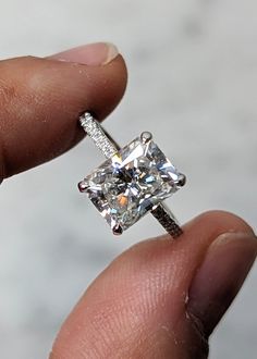 a person holding a diamond ring in their hand