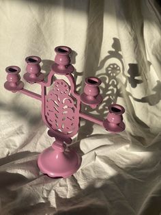 a pink candelabra sitting on top of a white sheet