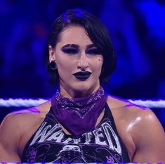 a woman with black makeup is standing in front of a rope and wearing a purple bandana