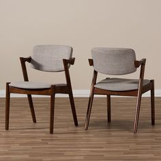 two chairs sitting next to each other on top of a hard wood floor