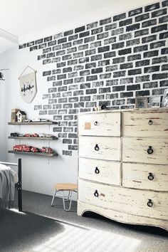 a bedroom with a brick wall and dresser