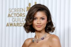 a woman in a strapless dress wearing a necklace and choker with jewels on it