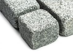 four pieces of gray granite sitting on top of each other in front of a white background