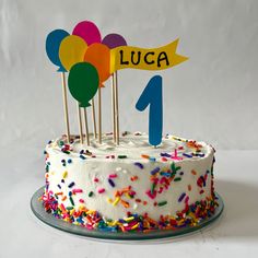 a birthday cake with white frosting and colorful sprinkles