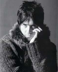 a black and white photo of a person wearing a sweater with a fur collar on