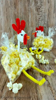 two chickens made out of popcorn sitting on top of a wooden table