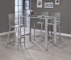 a glass table with four chairs and a bar stool next to it in a living room