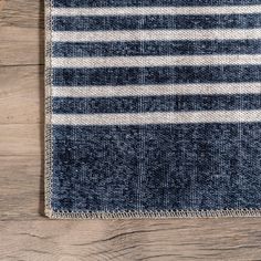 a blue and white striped rug on top of a wooden floor next to a phone