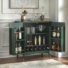 a green cabinet with liquor bottles and glasses on it in front of a white rug