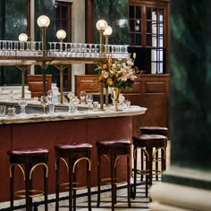 a bar with several stools in front of it and a clock on the wall