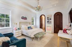 a bedroom with two couches, a bed and a chandelier hanging from the ceiling